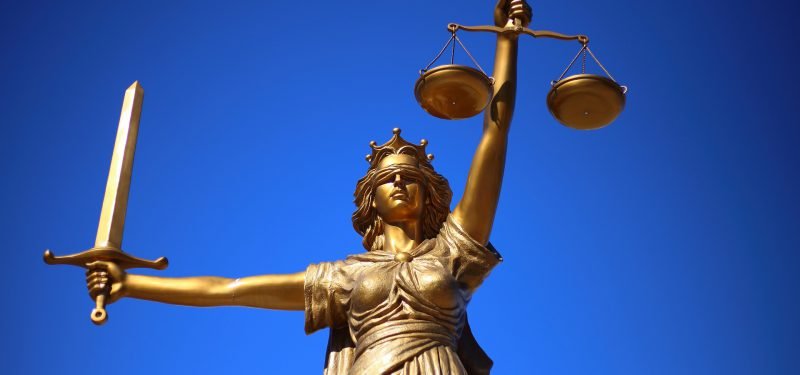 Statue der Justizia vor blauem Himmel