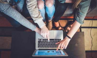 Junge Menschen arbeiten zusammen an einem Laptop