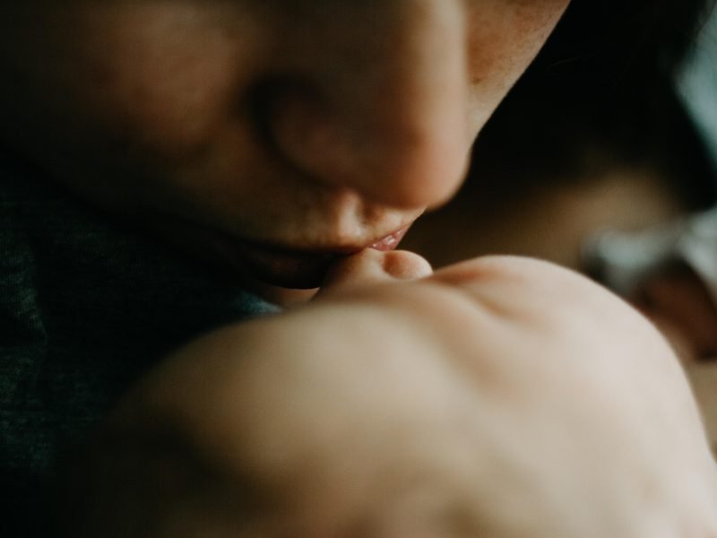 Mutter küsst ein neugeborenes Kind