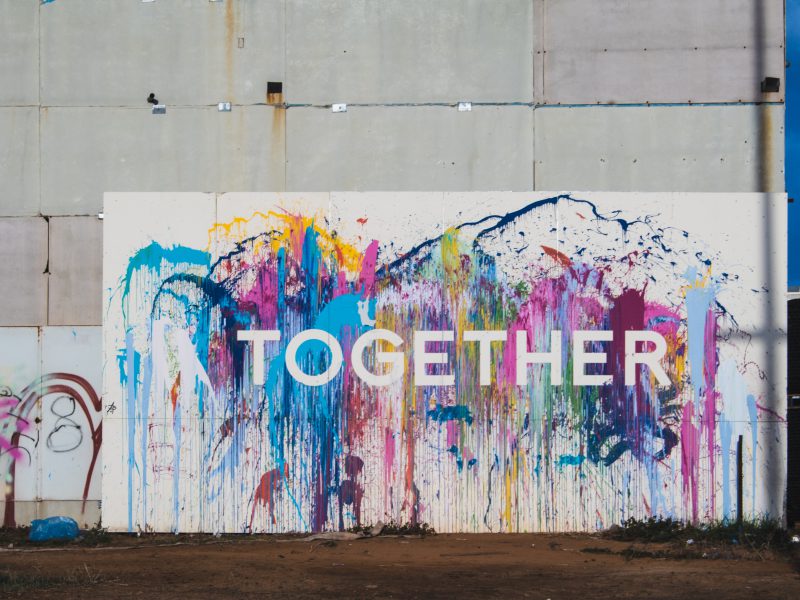 Es ist eine bunt bemalte Wand mit der Aufschrift "together" zu sehen