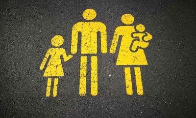 Es ist das gelbe Symbol einer Familie zu sehen, welches auf die Straße geklebt ist