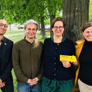 Turgut Altug, Silke Gebel und Clara Herrmann stehen vor einem Baum und freuen sich über den Beschluss zur Berliner Baumpflege