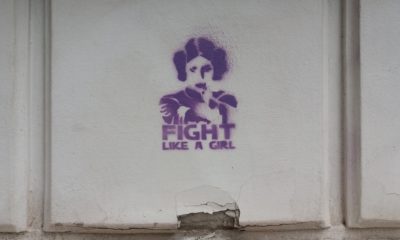 Auf dem Bild sieht man eine Hauswand mit Graffiti, auf dem steht: Fight like a girl.