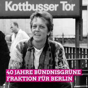 Auf dem Schwarz-Weiß-Bild sieht man Barbara Osterheld, die 1995 die erste weibliche Landtagsabgeordnete war, die ein grünes Direktmandat holte. Im Hintergrund sieht man ein Schild zum U-Bahnhof Kottbusser Tor. Außerdem steht im unteren Bilddrittel in großen weißen Buchstaben, die pink unterlegt sind, 40 Jahre Bündnisgrüne Fraktion für Berlin.