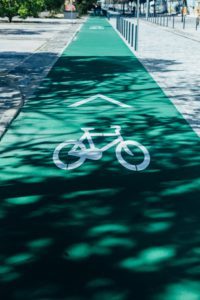 Es ist ein grüner Fahrradweg zu sehen auf dem ein weißes Fahrradsymbol ist.