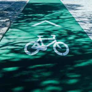 Es ist ein grüner Fahrradweg zu sehen auf dem ein weißes Fahrradsymbol ist.