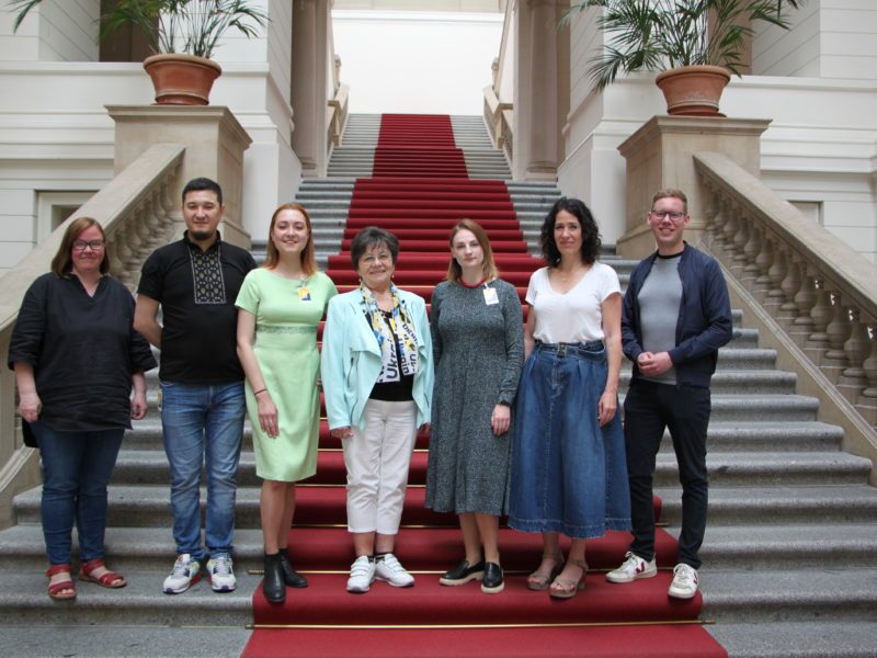 Sieben Teilnehmende des Austauschtreffens im Foyer des Berliner Abgeordnetenhauses