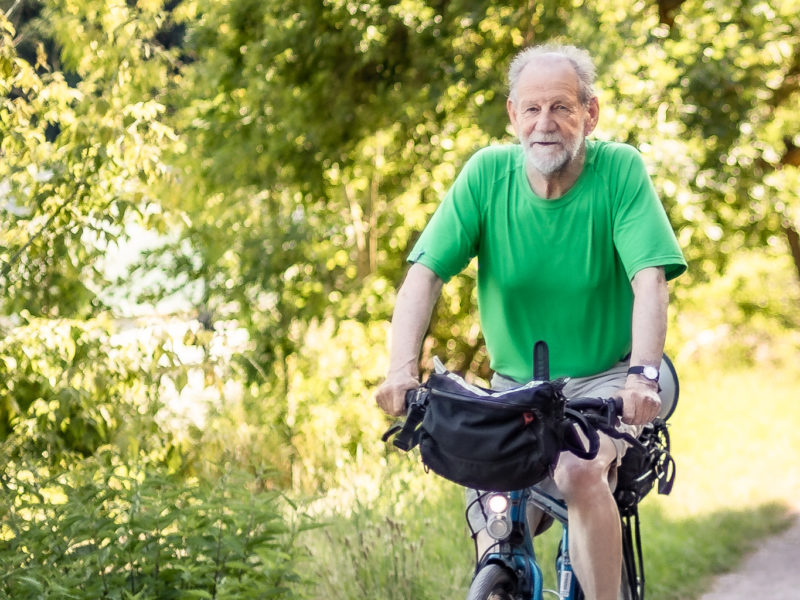 Michael Cramer fährt im Grünen auf einem Fahrrad. Er ist um die 74 Jahre alt und trägt ein grünes Shirt.