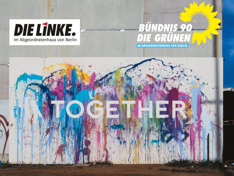 Es ist eine bunt bemalte Wand mit der Aufschrift "together" zu sehen. Darüber stehen die Logos der Grünen und Linken im Abgeordnetenhaus von Berlin