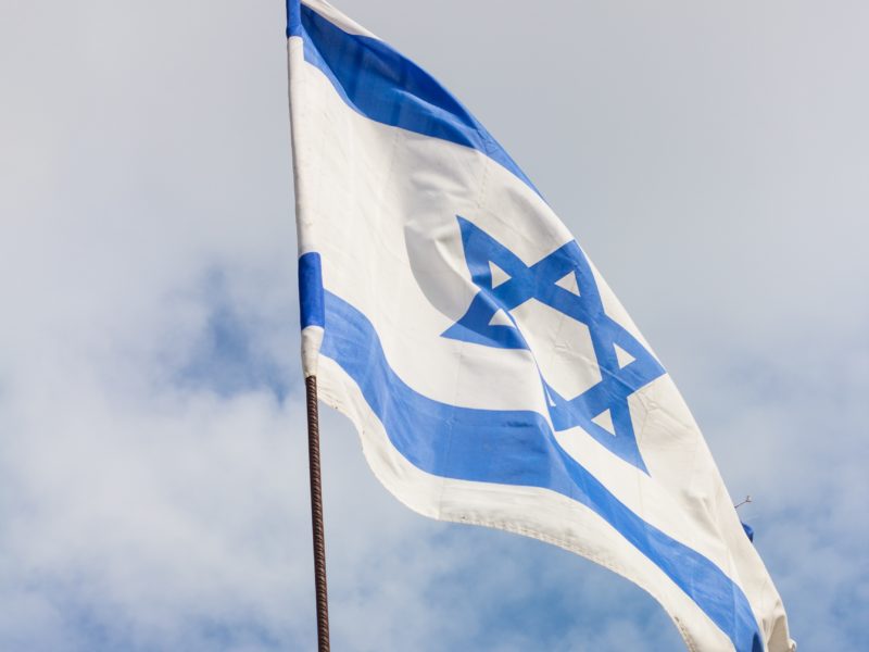 Ein Foto einer israelischen Flagge vor blauem Himmel.