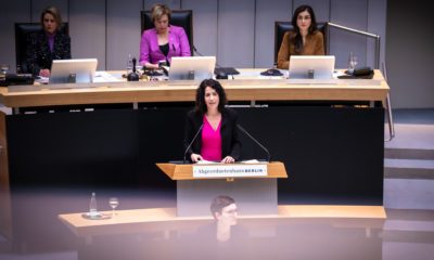 Bettina Jarasch steht am Redepult des Abgeordnetenhauses. Sie hält eine Rede, ihr Blick ist ernst. Sie trägt ein knallpinkes Kleid und einen schwarzen Blazer.